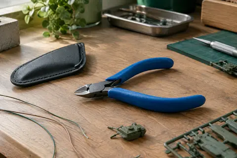 Mini pince coupante VCELINK à tête en acier et poignées bleues, posée avec sa housse sur un établi